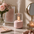 Pink Candlelight Aroma Diffuser Lamp on a marble surface with flowers and a mirror in the background