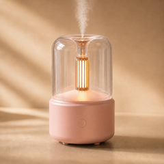 Pink diffuser with a warm amber glow and soft mist, shown on a neutral beige background.