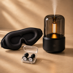 Black diffuser with warm mist, black sleep mask, and black earplugs arranged together in a calming bedtime bundle scene.